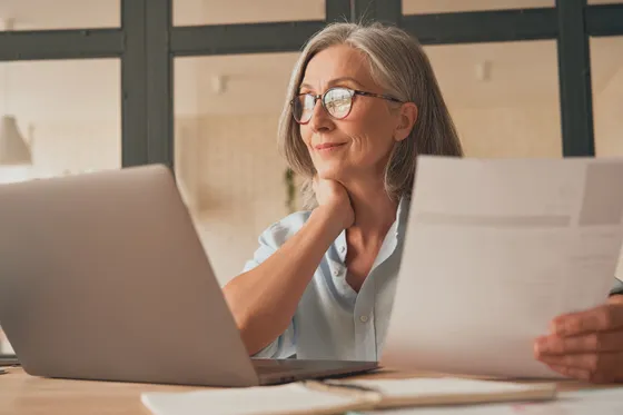 Psychologe die glimlachend nadenkt achter haar laptop